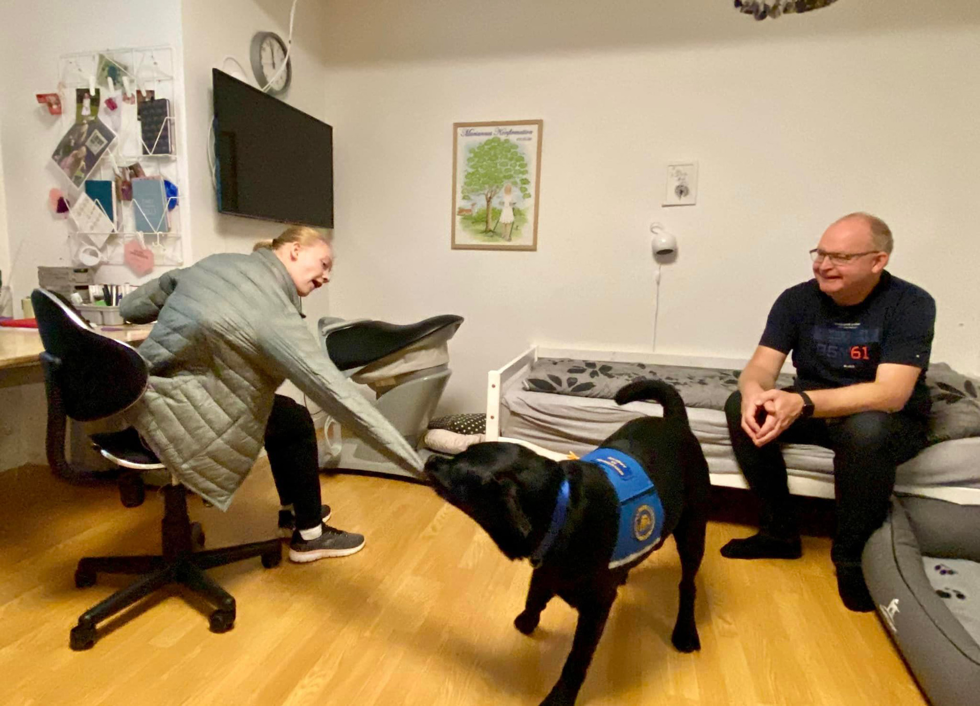 Servicehunden Stella hjælper bruger Marianne med at få en jakke af