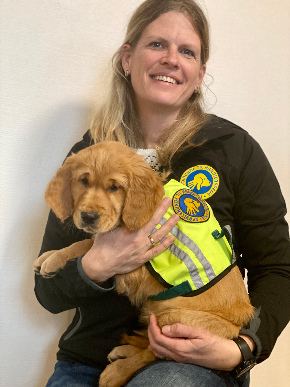 Hundeinstruktør der holder en hvalpeaspirant