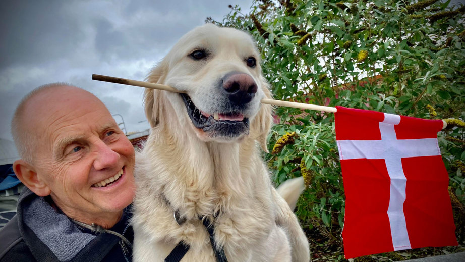 Bruger Buster og servicehunden Stormy med et flag i munden