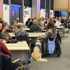 En masse familier og bestyrelsesmedlemmer til graduation for servicehunde og brugere