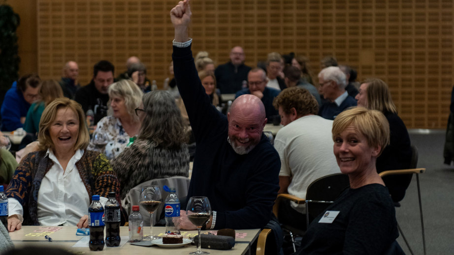 En mand der række armen op i luftet da han har vundet 
