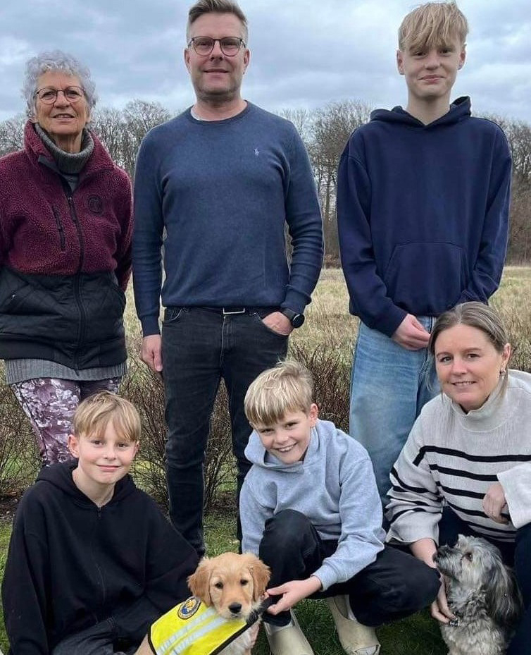 Servicehunden Daisy sammen med hvalpevært Maria og hendes familie