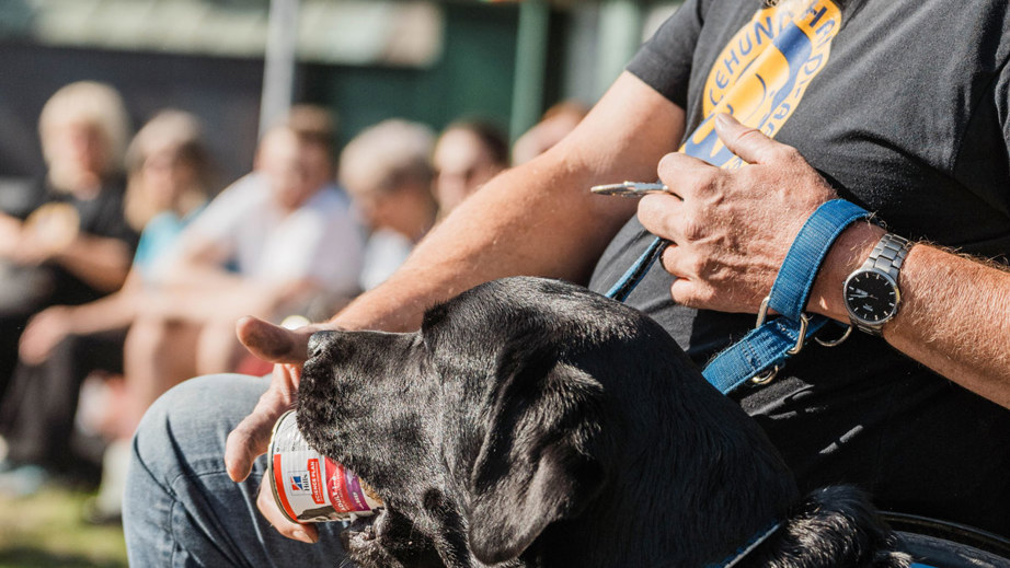 Jan sammen med en servicehund der har en dåse i munden