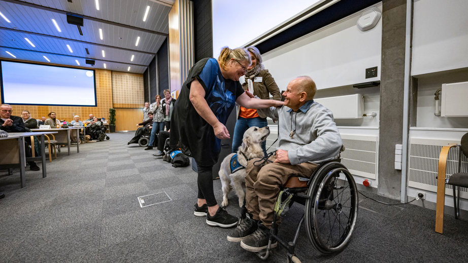 En dame smiler og ligger armen på brugers skulder til graduation