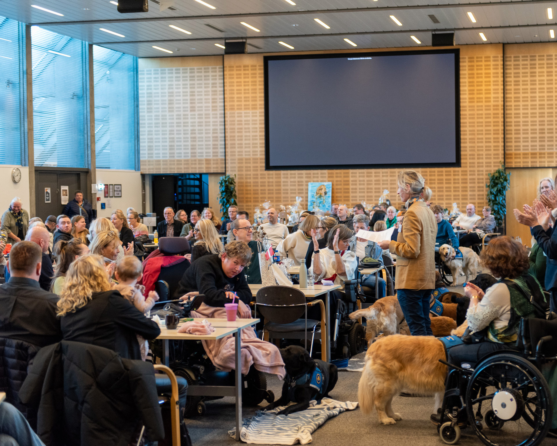 Bestyrelsesmedlem holder tale til bruger foran deres familier til graduation