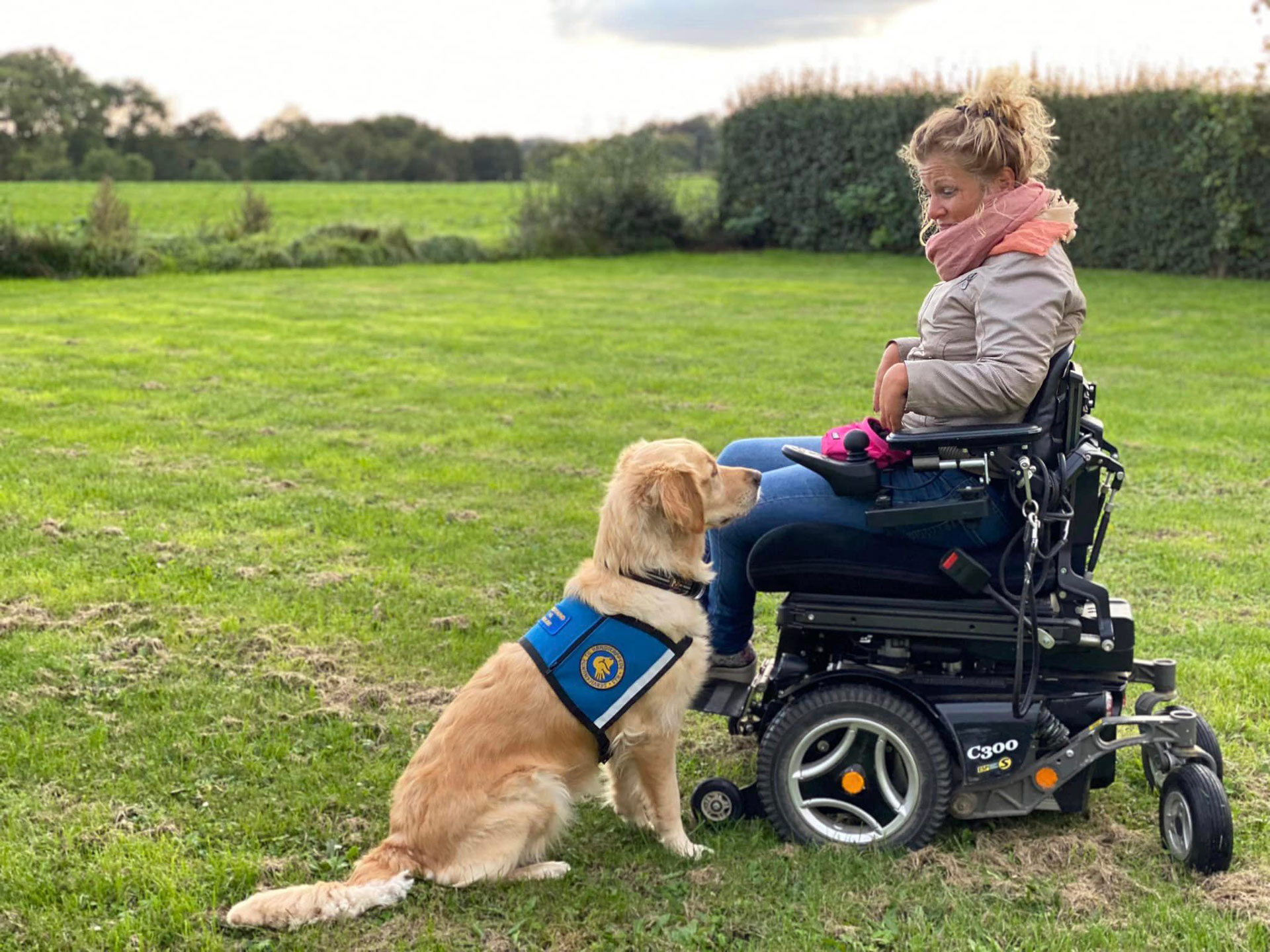 Servicehunden Roxy og bruger Rie sammen udenfor hvor de kigger på hinanden