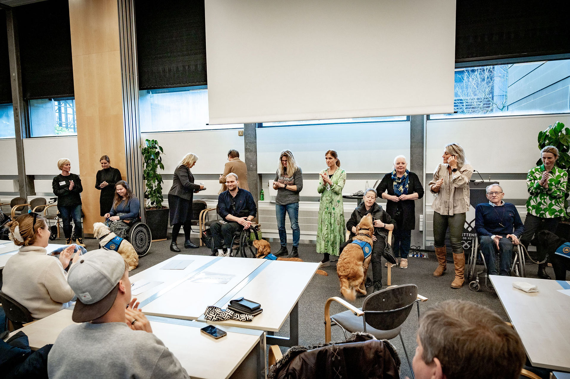 Bruger og servicehunde bliver vist frem på scenen til graduation