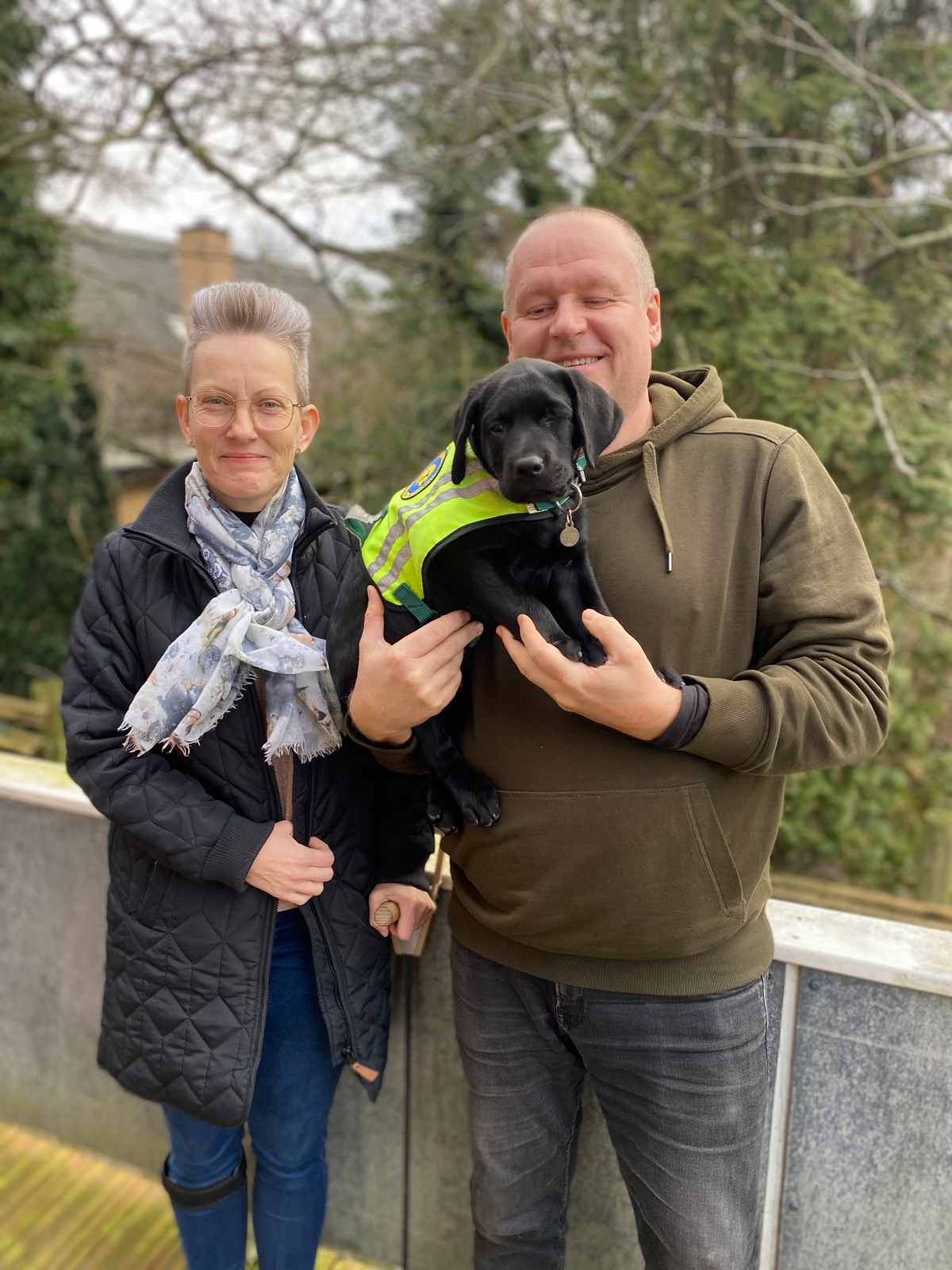 To hvalpeværter sammen med en sort hvalpeaspirant