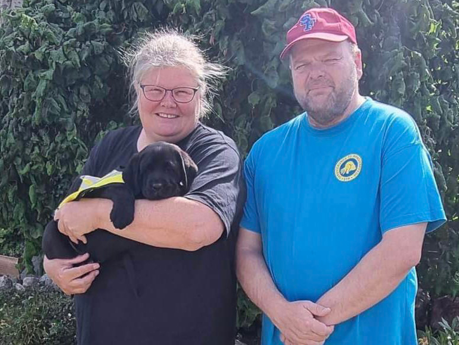 Hvalpeværterne Jette og Søren der står med hvalpeaspiranten Yukon